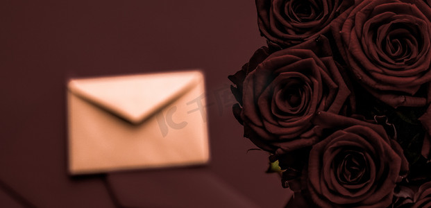 情人节送情书和鲜花，奢华的玫瑰花束和巧克力背景的卡片，适合浪漫的假日设计