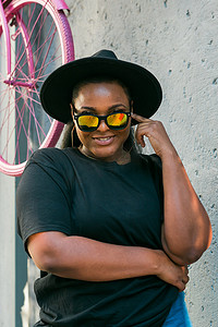 夏季户外广告摄影照片_特写肖像时尚年轻的非洲裔美国女孩，一头卷发，戴着时尚太阳镜，在城市里有复制空间和广告场所 — Instagram 风格的夏季时髦照片