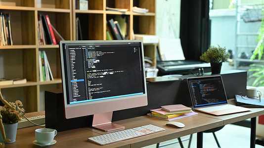 软件开发公司屏幕上带有编程代码的电脑和笔记本电脑