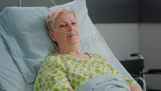 坐在医院病房床上的老妇人特写