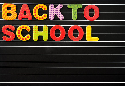 回到学校概念，黑板上有彩色磁性字母作为黑色背景。