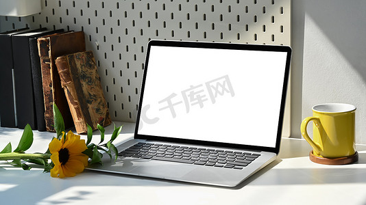 创意波普几何摄影照片_样机笔记本电脑、咖啡杯和向日葵放在白桌上。