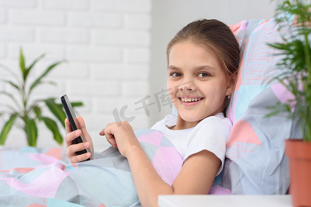 女孩玩着手机，开心地看着画面。