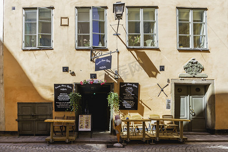 瑞典斯德哥尔摩摄影照片_瑞典斯德哥尔摩-2017 年 7 月 6 日。咖啡厅的门和桌子在户外敞开。