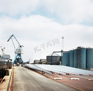 港口的物流、运输和供应链，背景有工厂、仓库或工厂和起重机。