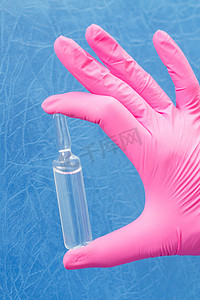 带安瓿和药物的粉色手套女医生的手