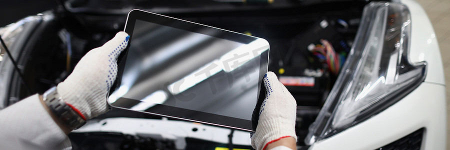 机械师在车前使用带有黑屏的平板电脑设备。