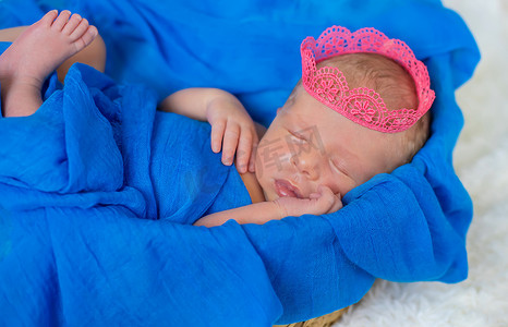 女孩皇冠摄影照片_戴着女孩皇冠的新生婴儿。