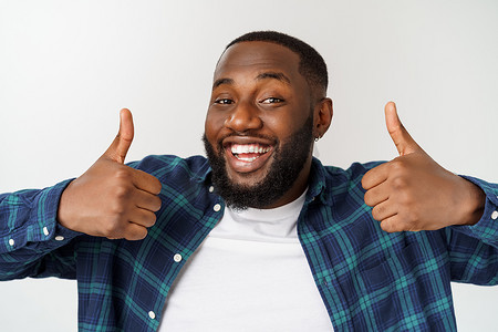快乐的非洲裔美国帅哥留着胡子的肖像笑着展示拇指手势。