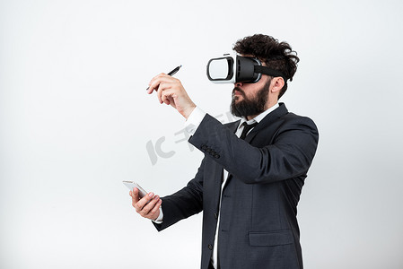 手机vr摄影照片_男子拿着手机，戴着 Vr 眼镜，用笔指着最近的更新。