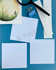 蓝色背景空纸提醒或用绘图水彩手工放大镜和回形针做列表的明信片模型。