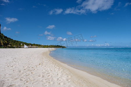 Le Morne 海滩毛里求斯，带棕榈树和白色沙滩蓝色海洋的热带海滩和带雨伞的沙滩床、太阳椅和遮阳伞在热带海滩的棕榈树下，Le Morne 海滩毛里求斯