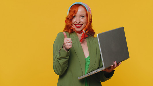 在笔记本电脑上在线工作的红发女孩表现出积极的良好反馈，例如彩票中奖