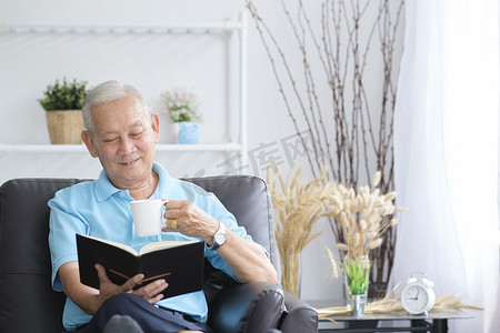 老人沙发摄影照片_老人看书，一个人呆在家里。