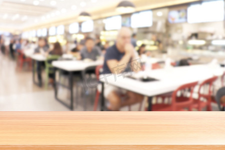 食堂摄影照片_模糊食堂餐厅的木板，很多人在大学食堂模糊背景中吃食物的空木桌地板，模糊咖啡馆或自助餐厅食堂的木桌板空着