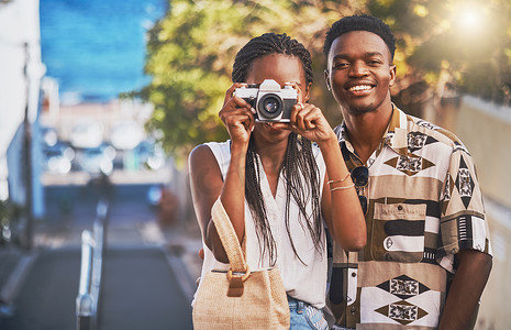 旅游夫妻摄影照片_旅行、旅游和年轻的黑人夫妇用相机拍照，在城市里玩耍和散步。