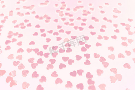 美丽的淡粉色心形五彩纸屑落在白色背景上。