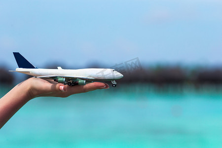 在绿松石海背景的小白色玩具飞机