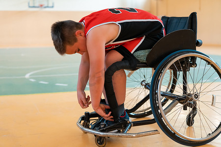 男孩坐在轮椅上，为大竞技场的篮球比赛开始做准备