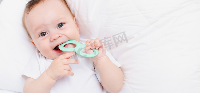 有孩子的家摄影照片_白色背景上有牙胶的婴儿。