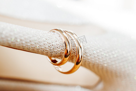 新娘鞋上镶有水钻的金色结婚戒指。