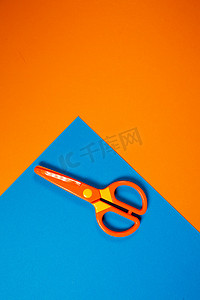 艺术彩色背景摄影照片_用于在彩色背景上剪纸人物的儿童塑料剪刀
