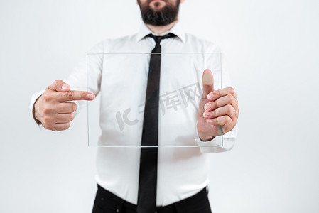 销售数据展示摄影照片_男性企业在展示销售数据时持有并指向透明玻璃。