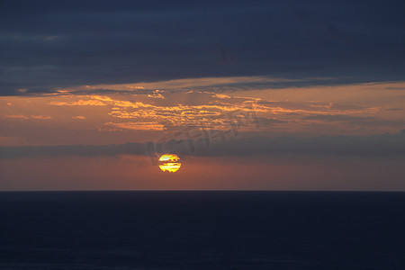 黎明破晓太阳在阴云密布的海洋地平线上