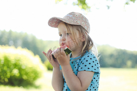 可爱的小女孩夏天在户外吃西瓜。