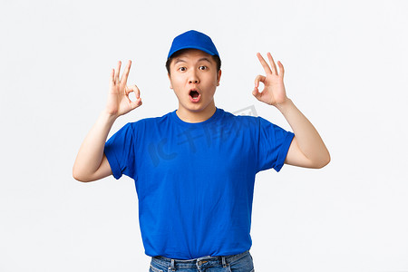 身穿蓝色制服的亚洲快递员对超酷的促销优惠反应深刻而惊奇。
