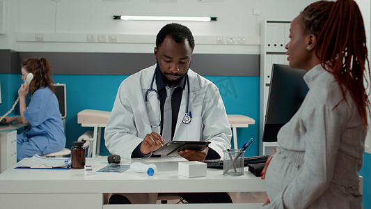 全科医生在产检时在数字平板电脑上做笔记