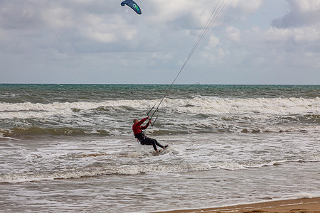 高难度动作摄影照片_专业的风筝手在美丽的背景下完成了高难度的动作。