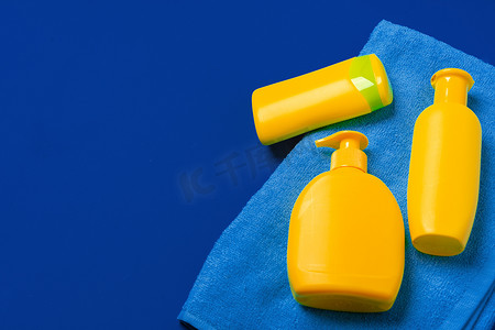 深蓝纸背景上的亮黄色瓶防晒产品