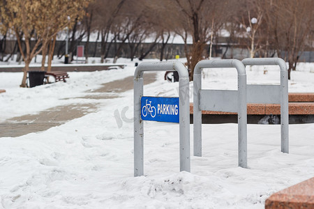 寒冷冬季雪地公园空自行车停车场，城市休闲区城市自行车站，多云天气