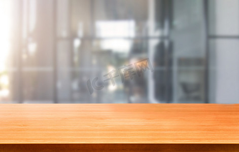 办公模糊背景摄影照片_市中心现代办公背景中的木桌