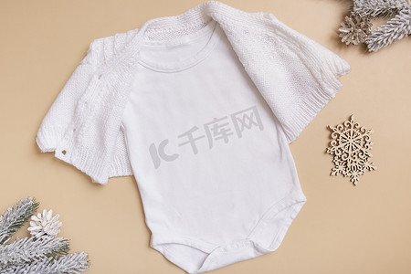 白色婴儿紧身衣模型，用于米色背景上的徽标、文字或设计，并具有冬季装饰顶视图