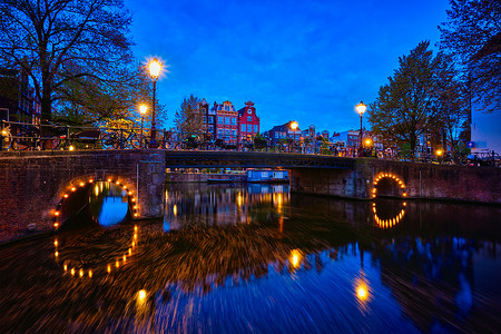 荷兰语摄影照片_阿姆斯特丹运河、桥梁和中世纪房屋在晚上