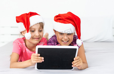 兴奋的小妹妹们一起在现代平板电脑小工具上浏览和玩耍时玩得很开心。