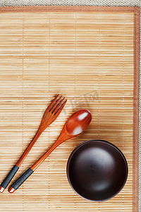 天然木盘、勺子和叉子在竹背衬上。