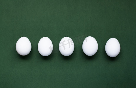 鸡蛋加工摄影照片_深绿色背景上躺着五个鸡蛋