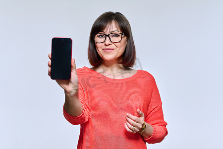积极的中年女性展示智能手机屏幕