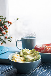 牛油果咖啡摄影照片_健康早餐：鸡蛋、鳄梨、葡萄柚和一杯咖啡。