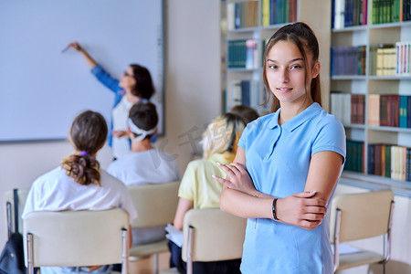 镜头组摄影照片_图书馆里微笑着看着镜头的女青少年学生、一群学生和师生