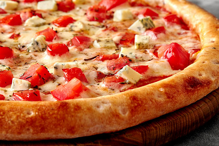 帕拉佐摄影照片_木制服务板上的披萨，配马苏里拉奶酪、西红柿、戈贡佐拉和干香草