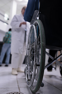 在私人诊所接待处与医生交谈的残疾人使用轮椅的特写镜头