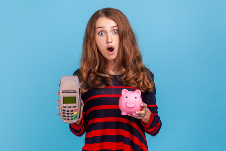 钱表情摄影照片_展示 pos 支付终端和空屏智能手机的女士表情惊讶。