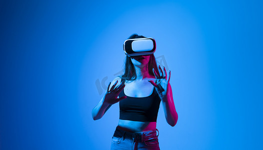令人印象深刻的黑发女性使用虚拟现实耳机，获得沉浸式体验，与沉浸式数字世界互动，测试 VR 技术。