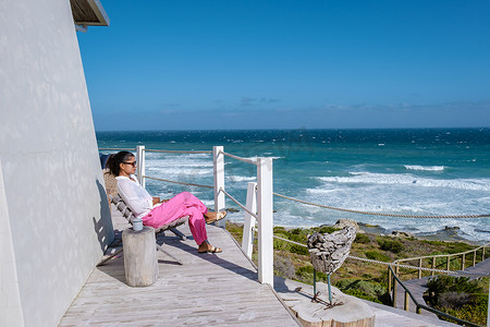 西开普省摄影照片_在阳台上观看海洋的女人德霍普自然保护区南非西开普省，德霍普自然保护区的白色沙丘是花园路线的一部分