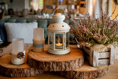 白色燃烧的灯笼，木盒里的石南花，木桌上装饰着秋季风格，松角，核桃和乡村风格的蜡烛，秋天的概念。