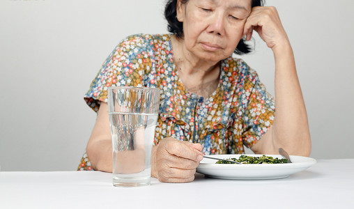 老人生气摄影照片_厌倦食物的亚洲老妇人